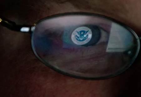The Department of Home Security logo reflected in a pair of glasses