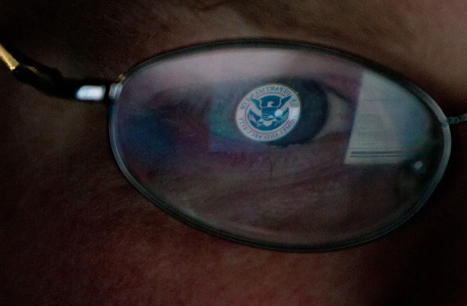 The Department of Home Security logo reflected in a pair of glasses